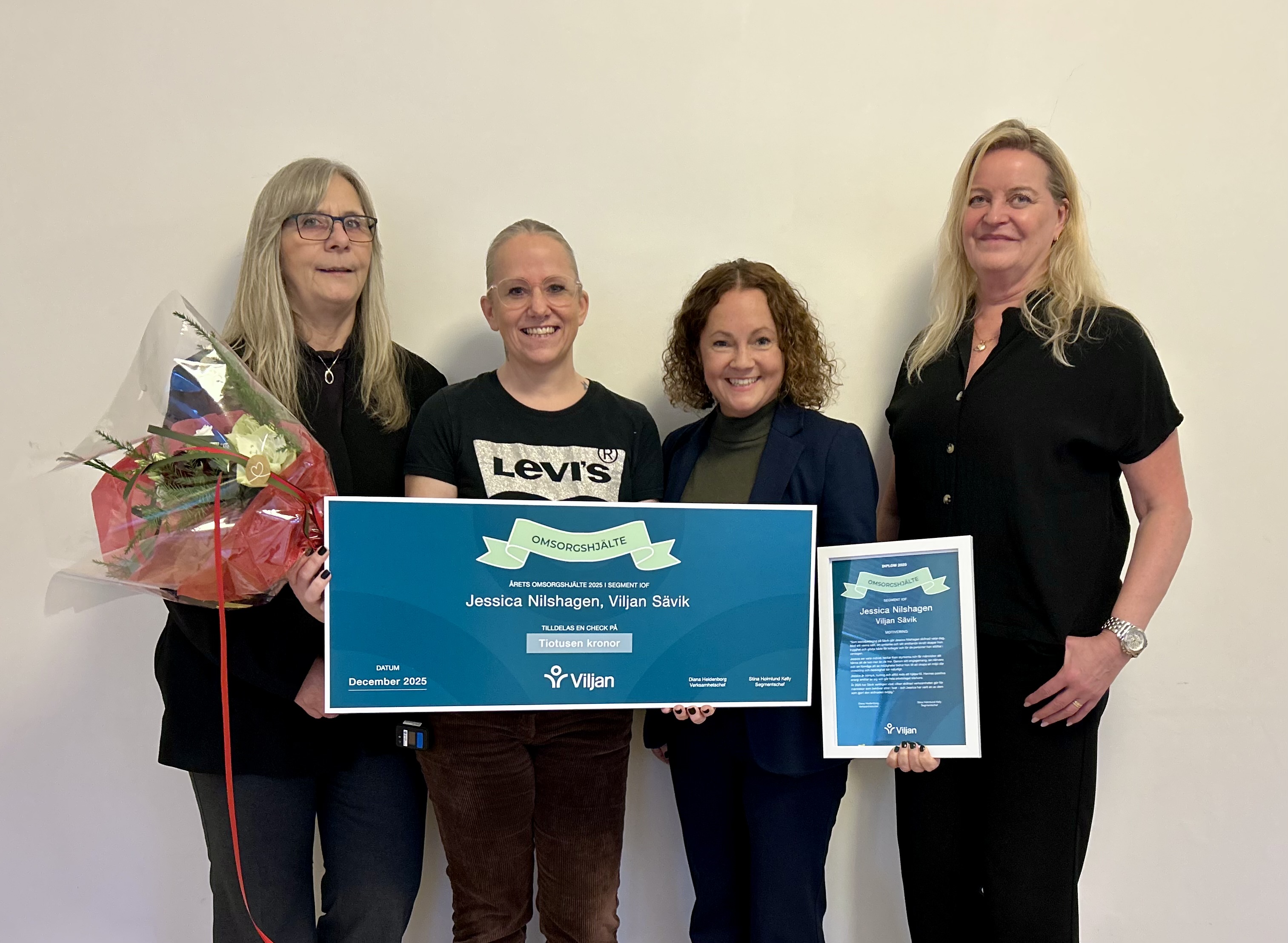 Omsorgshjälten Jessica håller i sin check, omringad av chefer från Viljan som presenterade priset