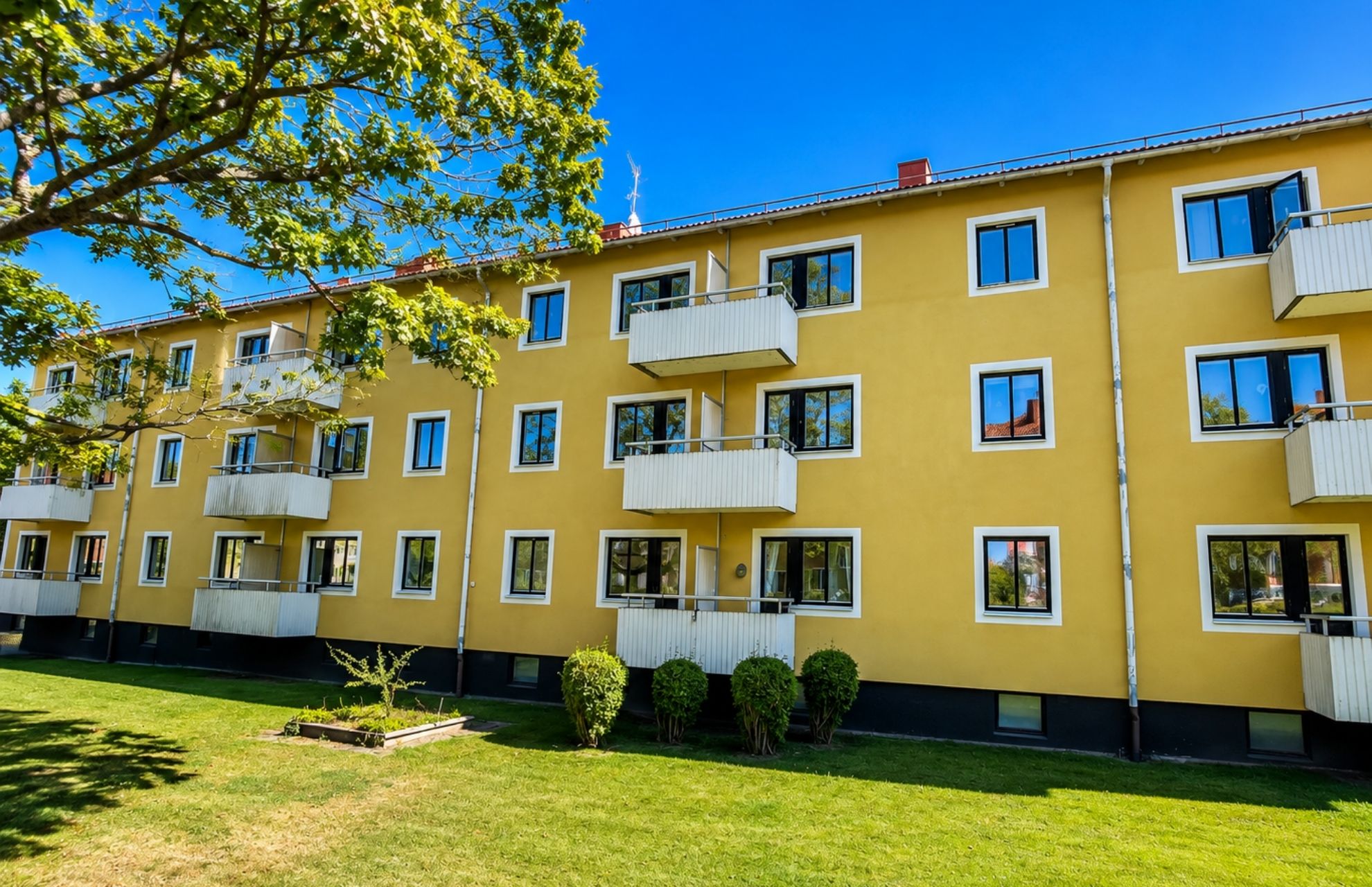 Flerfamiljshus i ett lugnt bostadsområde med gröna träd 