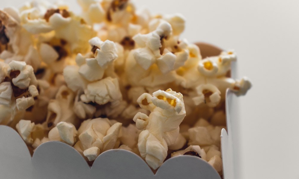 Popcorn i en vit kartong mot en ljus bakgrund